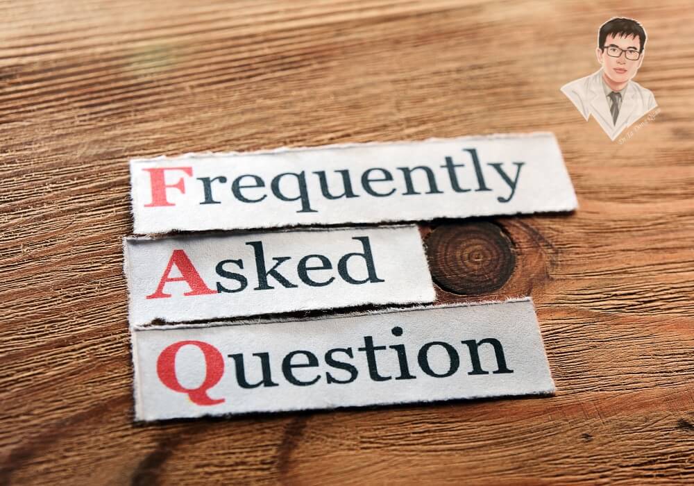 Hình ảnh "Frequently Asked Questions" trên bàn gỗ, thể hiện mục giải đáp thắc mắc về tình trạng tụt nướu lộ chân răng.