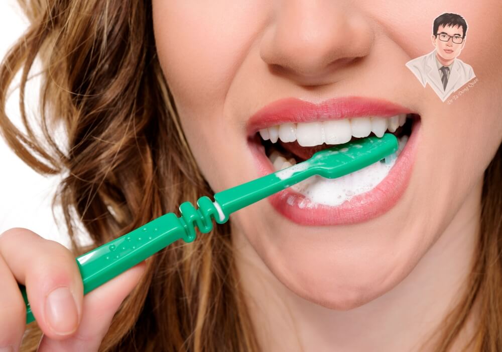 Một người phụ nữ đang chải răng đúng cách bằng bàn chải lông mềm để bảo vệ nướu và phòng tránh tụt nướu.