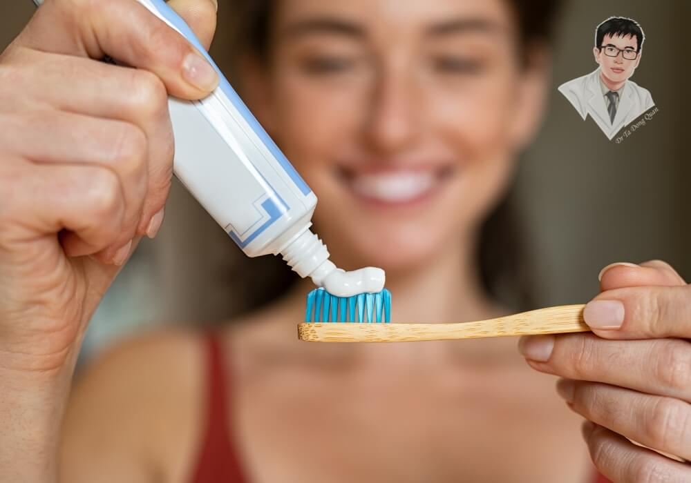 Người phụ nữ mỉm cười khi lấy kem đánh răng và chuẩn bị chải răng, thể hiện thói quen vệ sinh răng miệng đúng cách để ngăn ngừa tụt nướu.