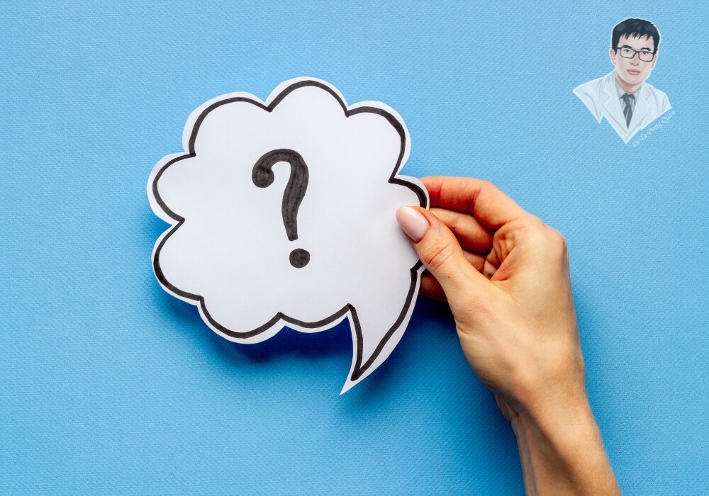 Hình ảnh một bàn tay đang cầm biểu tượng dấu hỏi, thể hiện sự băn khoăn giữa việc trị tụt nướu tại nhà hay đến nha khoa.